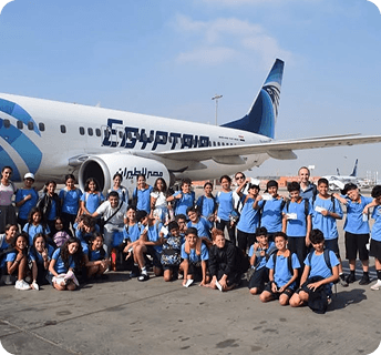 Students enjoying a trip in front of an EgyptAir plane