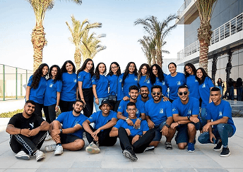 Students in blue shirts sitting outdoors